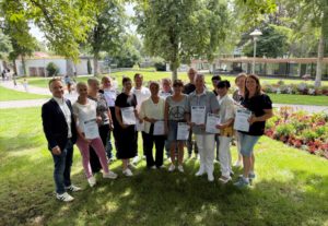 Eine Gruppe Menschen in einem Park mit Urkunden in den Händen