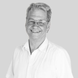 Lächelnder Mann mit weißem Hemd und Brille